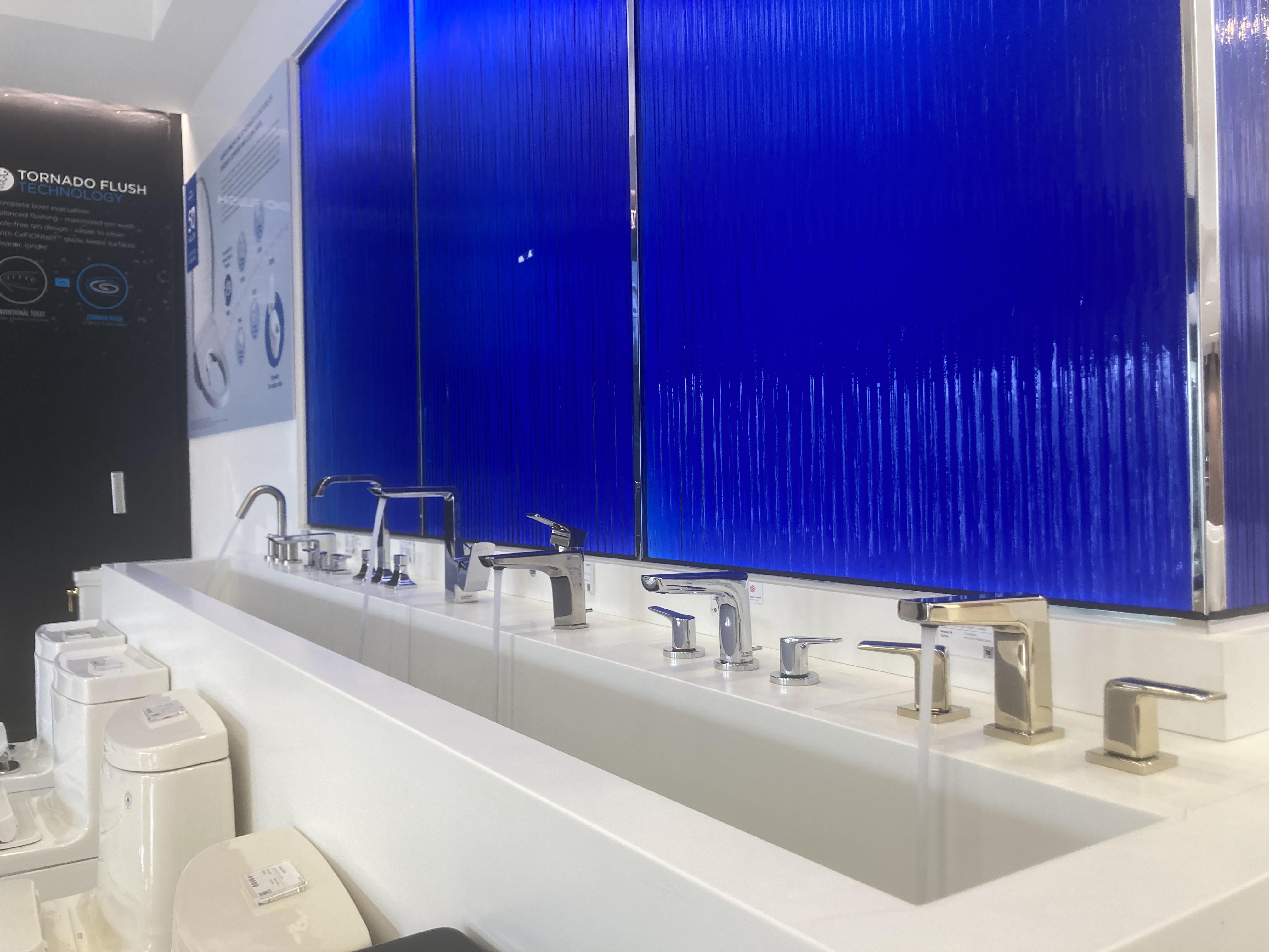 Faucets on display in front of blue textured glass